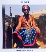 Cover of the 2023 Kom diary, a portrait of the Paramount Fon of Kom seated in blue and red cloth